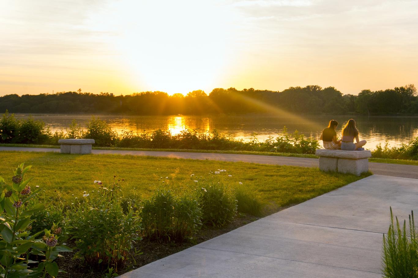 Young women watching the sunset at Perrysburg's multi-level riverfront park pathways that echo the river.