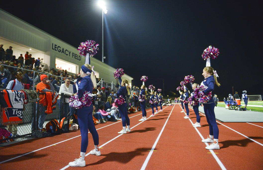Cheerleaders leading the crowd at a night football game at KIPP Legacy Stadium. 